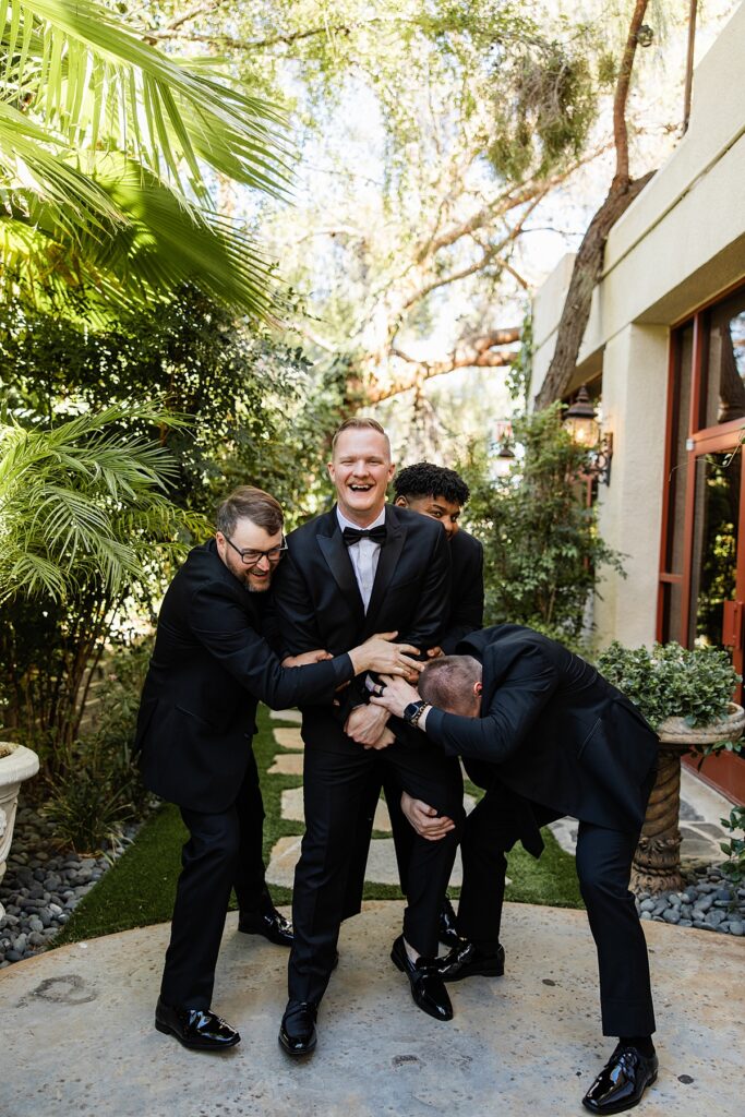 A groom laughs surrounded by his groomsmen before eloping to Las Vegas 