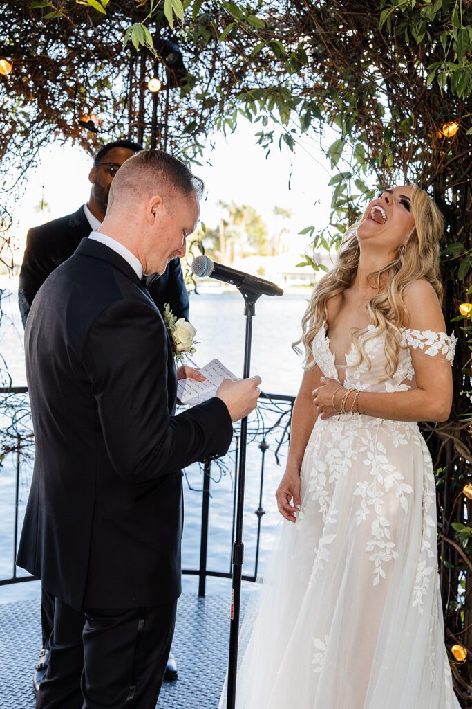 A bride laughs during personalized vows at lakeside wedding and events