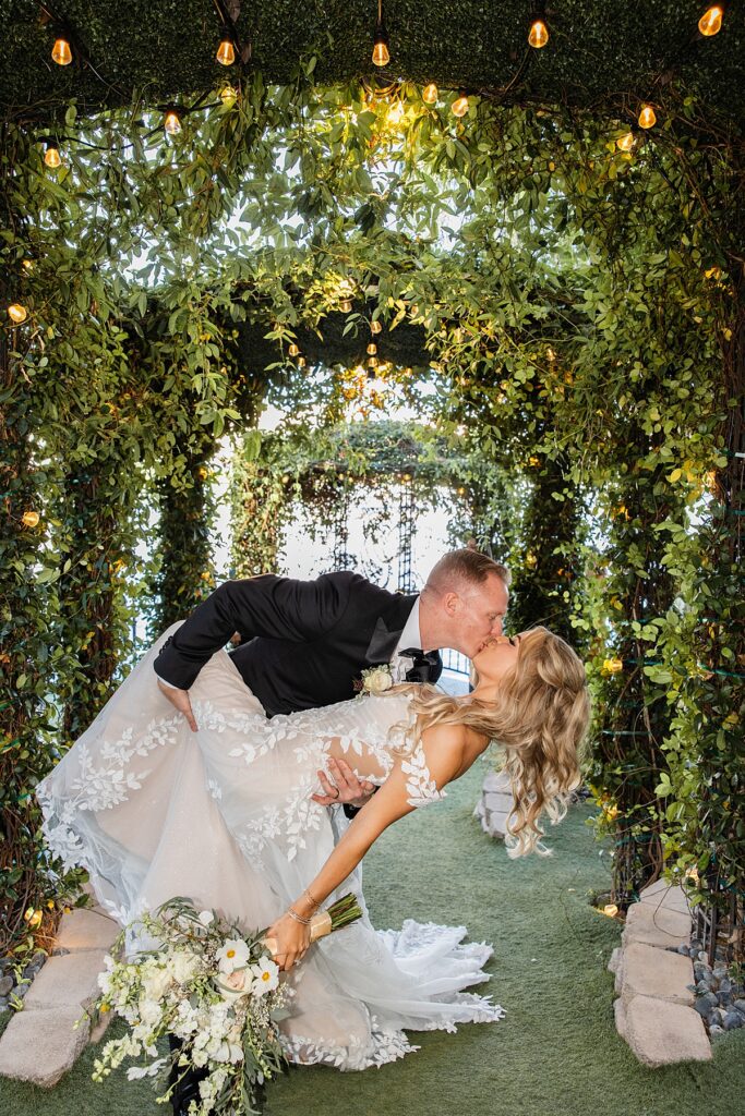 Newlyweds share a kiss beneath string lights at their Las Vegas elopement 